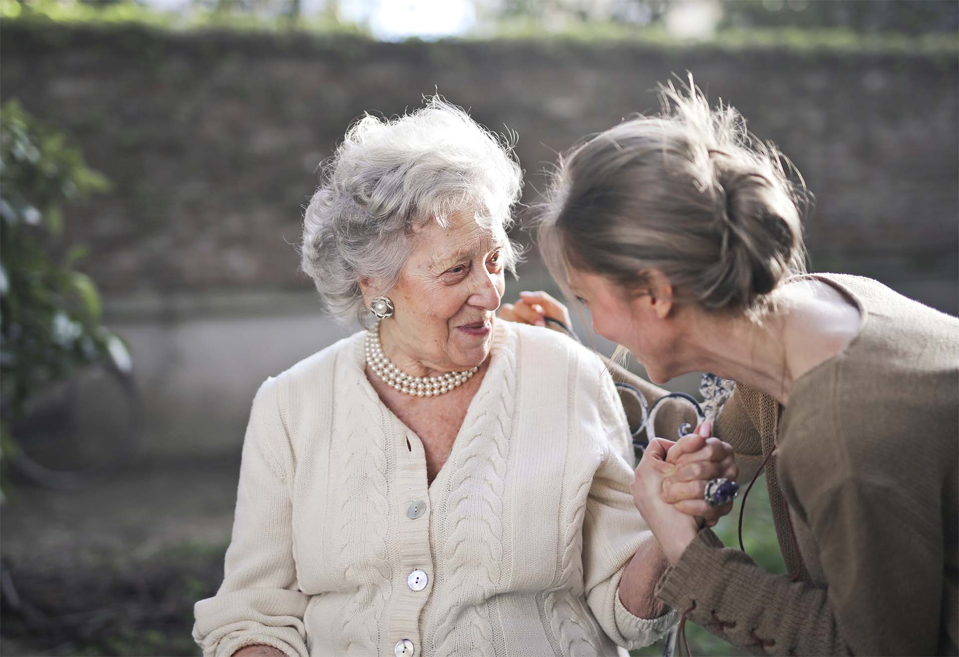 women smiling in care home garden space