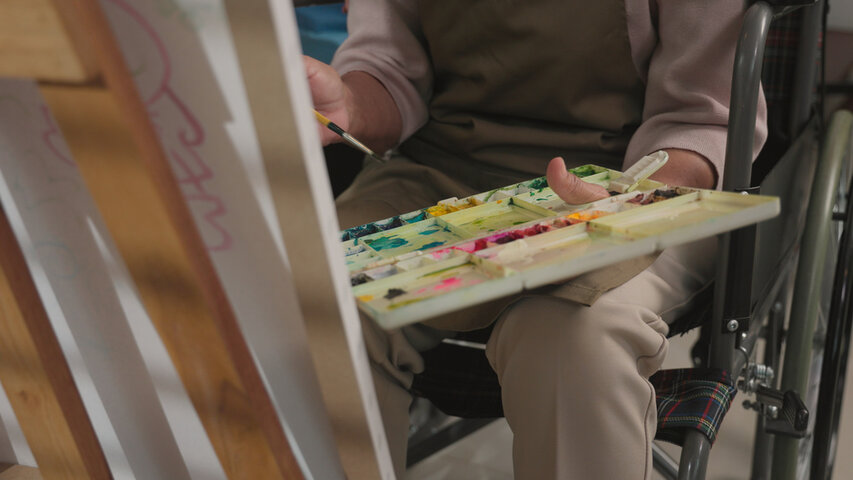 woman in wheelchair painting