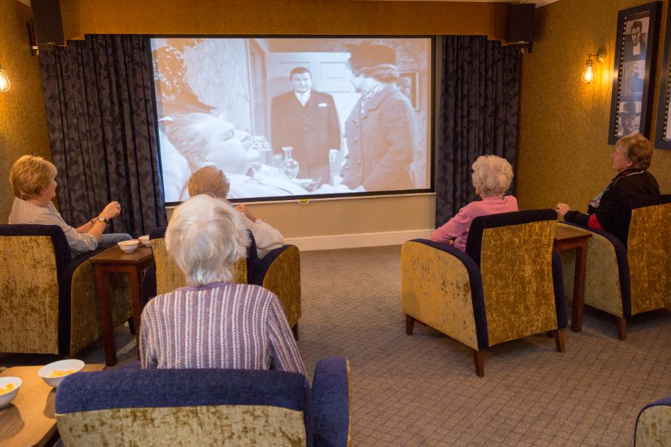 Residents watching a black and white movie in the Chetwynd House cinema room