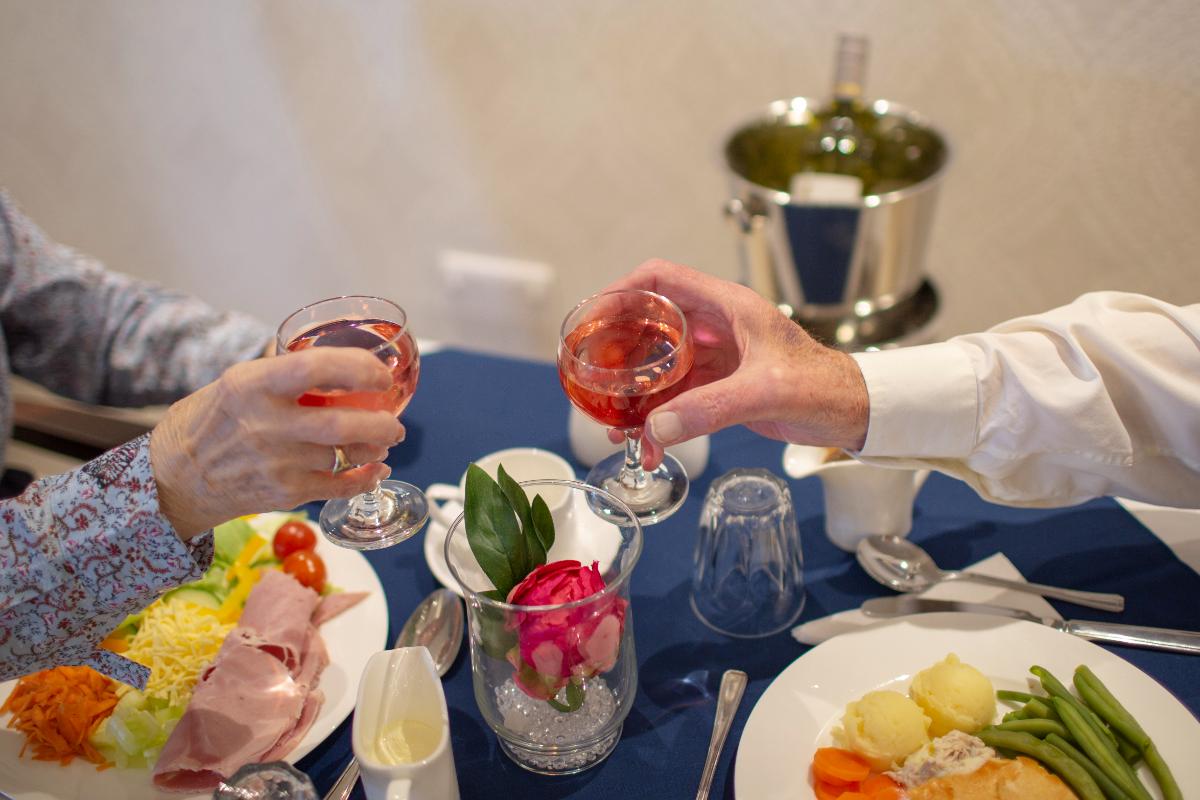 Residents dining at Chetwynd House Care Home with a glass of wine
